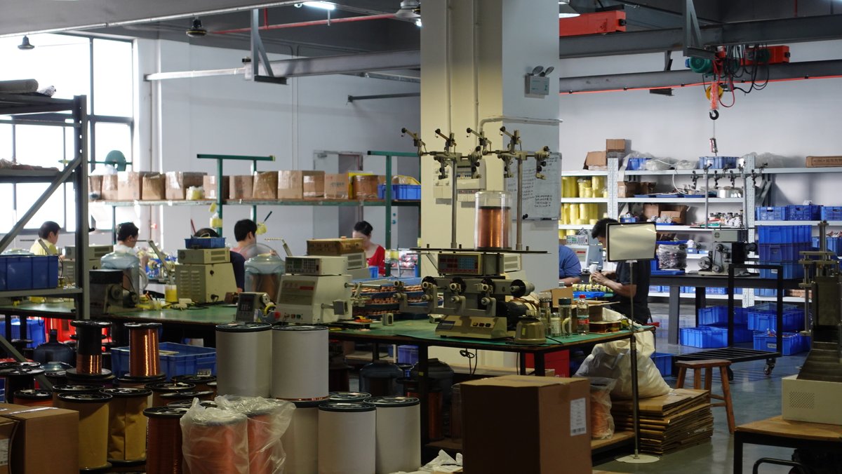 绕线工位全景：多台绕线机排布，台面与架上可见在制线圈